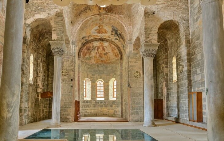 Trabzon Ayasofya iç mekanı; apsis bölümü, Bizans dönemine ait freskler, mermer sütunlar ve nave olarak bilinen ana ibadet alanı görülüyor. Komnenos taş işçiliği ve fresk sanatı detayları seçilebiliyor.